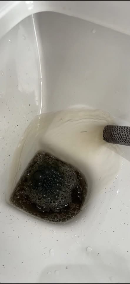 Dirty sludge water drained during central heating powerflush
