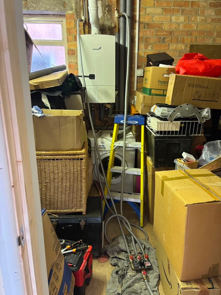 Cluttered utility area around old boiler before service